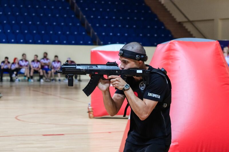 Боец LASERWAR с автоматом нацеливается в игре.